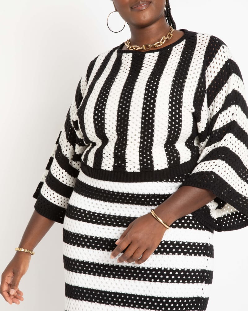 Side of a model wearing a size 14|16 Wide Sleeve Striped Sweater in Black And White Stripe by ELOQUII. | dia_product_style_image_id:290201